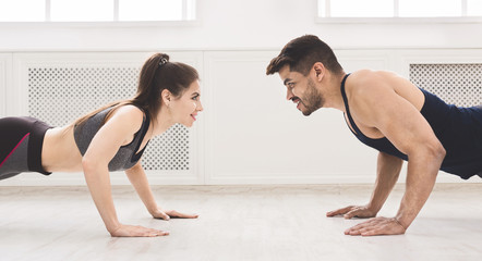 Obraz premium Sporty couple standing in plank in front of each other