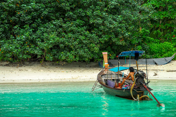Naklejka na ściany i meble Boat stopped at Loh Samah Bay beach with crystal clear water, island of Ko Phi Phi, Phuket, Thailand