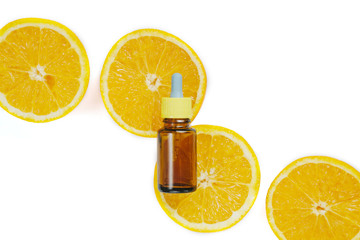 Bottle citrus essential oil and fresh juicy orange fruit on white background. High dose vitamin c synthetic for skin. Flat lay, top view, copy space