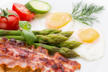 Fried eggs with bacon on the wooden table.