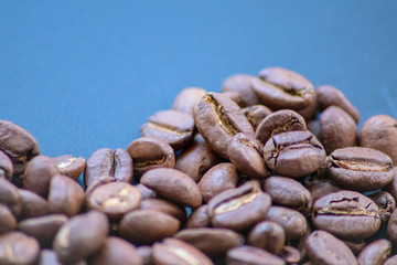 Ganze Kaffeebohnen vor neutralem Hintergrund symbolisieren Kaffeegenuss für echte Kaffeeliebhaber