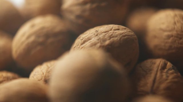 Closeup Product Shot Of Organic Walnuts, Rotating In Studio.