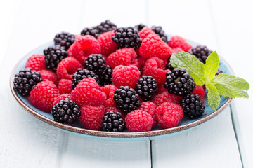 Fresh raspberries in a plate on a  vintage background.