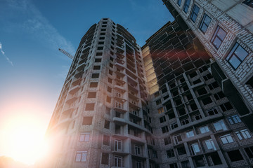 Fototapeta premium Construction site of new modern residential building at sunset sky background