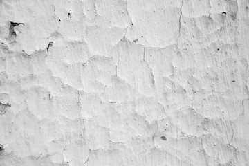 An old ragged plaster  white wall texture, cracked and old  for background,rough cement wall