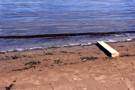 River beach with lath desck and small waves and clear water and wet sand