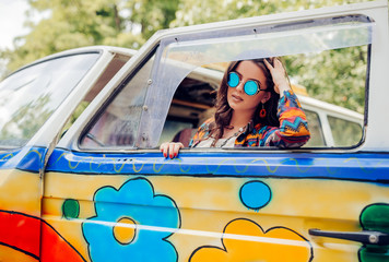 Cheerful close up portrait beautiful caucasian woman out of the van window during travel vacation - smile and enjoy modern hippy lifestyle - colors and joy concept for middle age people 