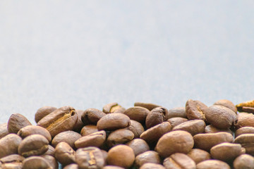Ganze Kaffeebohnen vor neutralem Hintergrund symbolisieren Kaffeegenuss für echte Kaffeeliebhaber