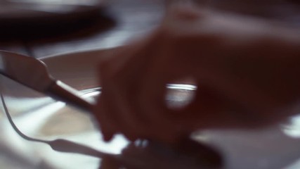 light moving on silver spoon , fork and knife in white dish , dinner setting or open scene for food restaurant or cuisine cooking concept