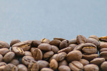 Ganze Kaffeebohnen vor neutralem Hintergrund symbolisieren Kaffeegenuss für echte Kaffeeliebhaber