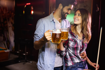 Couple drinking beer and playing snooker on date