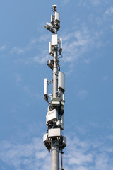 Fototapeta premium Antenna tower building. Technology Cellular Station, Wireless Communication Transmitter on Outdoor Poles Power , micro system 4G, 5G, base stations in urban areas on the blue sky and white cloud.