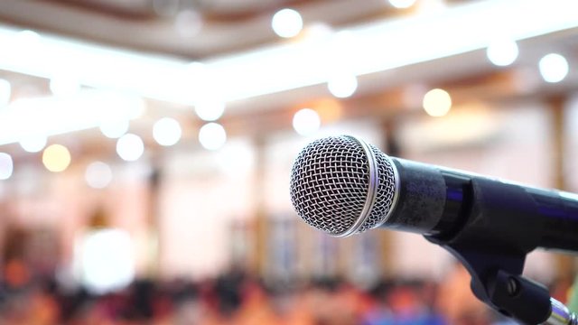Seminar Conference Concept : Close-up Microphones on abstract blurred of speech in conference meeting room, front speaking blur bokeh light in event convention hall in hotel background