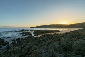 Fototapeta na wymiar Hinter dem Strand von Aragunnu Bay im Mimosa Rock National Park NSW Australien geht die Sonne auf