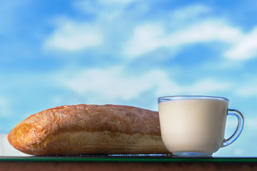 Fresh tasty bread with milk on the background of nature in summer.