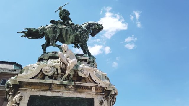 4K Statue of Prince Eugene of Savoy. The statue is at the centre of the scene. A blue sky full white clouds are in the background. People walk and take pictures around the statue.