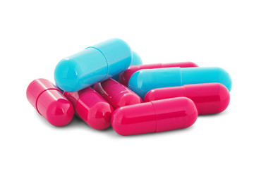 Pile of medical pills in red and blue colors on white isolated background with shadow.