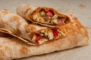 Shawarma, fresh roll of pita, chicken, vegetables. Traditional Middle Eastern snack.
