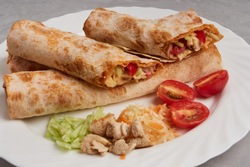 Shawarma, fresh roll of pita, chicken, vegetables. Traditional Middle Eastern snack.