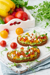avocado toast with feta and tomatoes, smorrebrod with ricotta, closeup and vertical