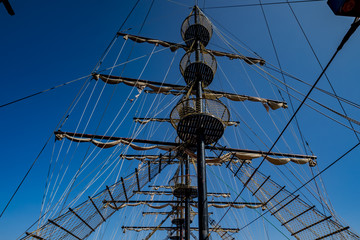 Low viewing angle of three masts of a sailing vessel. 
