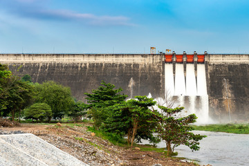 Amazing and beautiful water release at spillway or overflows at big dam with blue sky and cloud (Khun Dan Prakan Chon dam in Nakhon Nayok province Thailand)