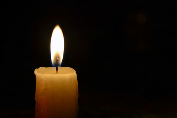 Lonely candle close-up on black background