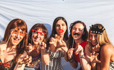 group of female friends having fun with party accessories on the roofs