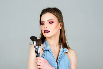 Emphasize femininity. Girl apply powder eye shadows. Looking good and feeling confident. Makeup dark lips. Attractive woman applying makeup brush. Professional makeup supplies. Makeup artist concept