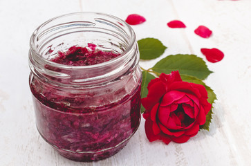 Jam of rose petals in a glass jar on a light background. Flower confiture. Healthy food.