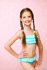 Portrait of cute smiling little girl child schoolgirl teenager in swimsuit isolated