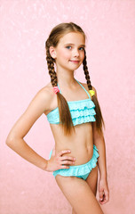 Fototapeta premium Portrait of cute smiling little girl child schoolgirl teenager in swimsuit isolated