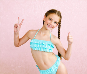 Portrait of cute smiling little girl child schoolgirl teenager in swimsuit and finger up isolated - 273633269