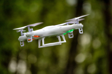 White drone quadcopter taking off from the ground. Soft focus. Motion blur.