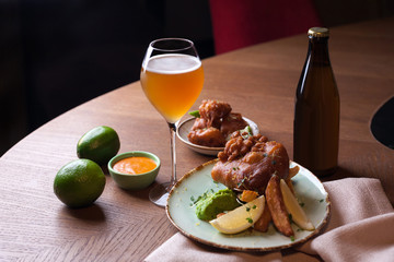Battered fish with fried potatoes and glass of beer