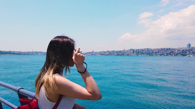 Slow motion:Beautiful girl takes pictures of Bosphorus,a popular destination in Uskudar town,Istanbul,Turkey