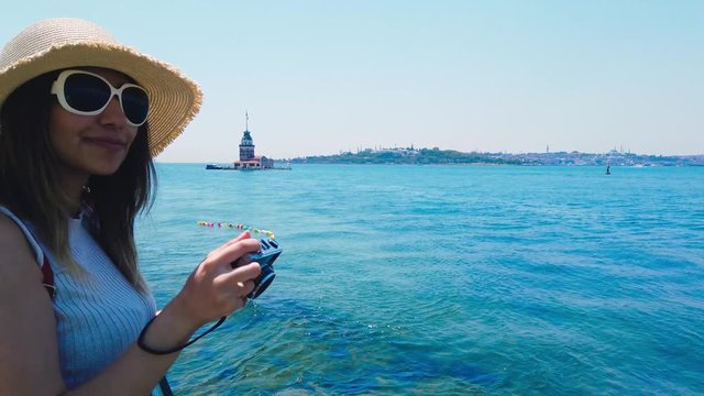 Beautiful girl takes pictures of Bosphorus  and  Maidens Tower in Uskudar town,Istanbul,Turkey