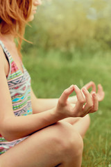 Hand of a woman meditating in lotus position practicing yoga in summer.Active Lifestyle. Healthy and yoga concept. Fitness and sports