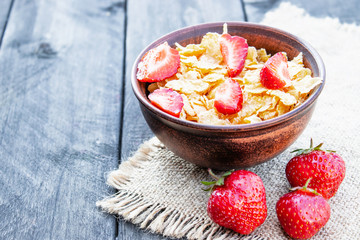 Fresh homemade muesli, muesli with strawberries in a plate on a dark gray background, selective focus