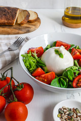Fresh salad with italian burrata cheese, juicy tomatoes, balsamic vinegar and olive oil