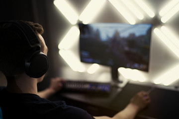 Professional gamer in his expensive studio young man having live stream playing online video game....
