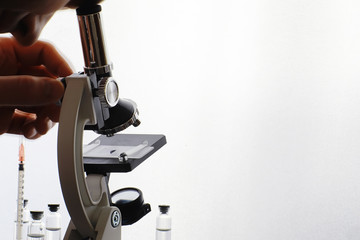 Research laboratory. Test tubes and microscope on the table on a white background.