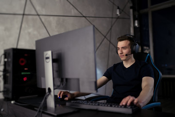 Professional gamer playing online video game at night time