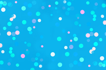 Colored confetti bokeh on blue background.