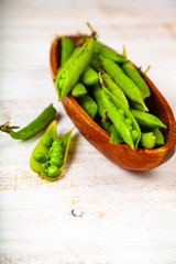 Green peas in a wooden bowl.