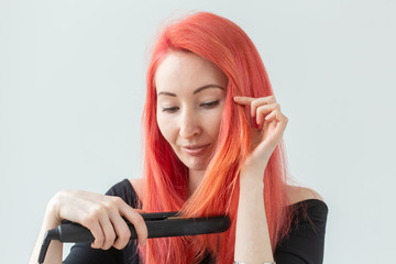 Hair style, hairdresser and people concept - stylish red-haired woman with curling iron on white...