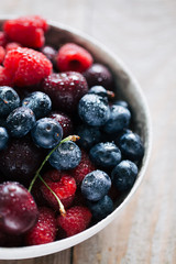 fresh berries covered by water drops in a bowl