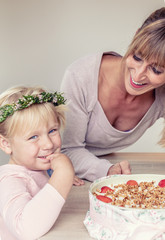 Mutter und Tochter kosten am Kuchen