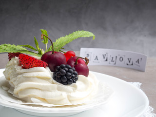 Pavlova cakes with cream and fresh summer berries, blackberry, strawberry, cherry, currant, mint leaf, copy space