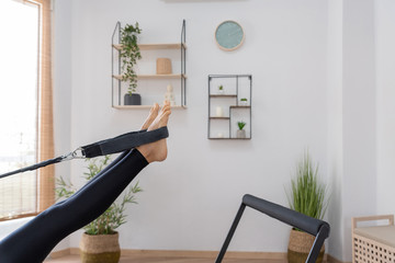 Young woman exercising on pilates reformer bed